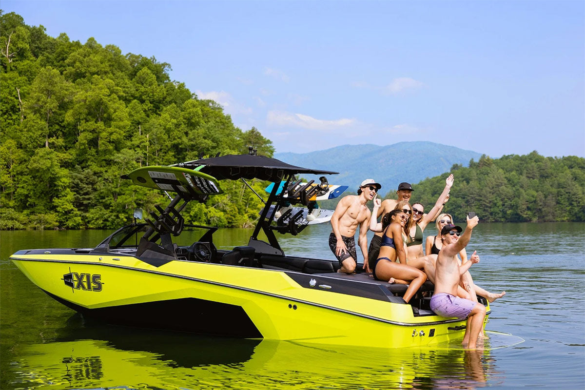 A group of people take a picture on the back of an Axis A Series boat.