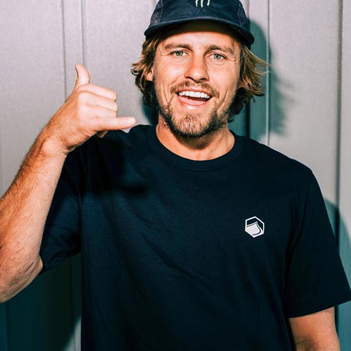 Man smiling in black Liquid Force shirt and hat making shaka hand sign.