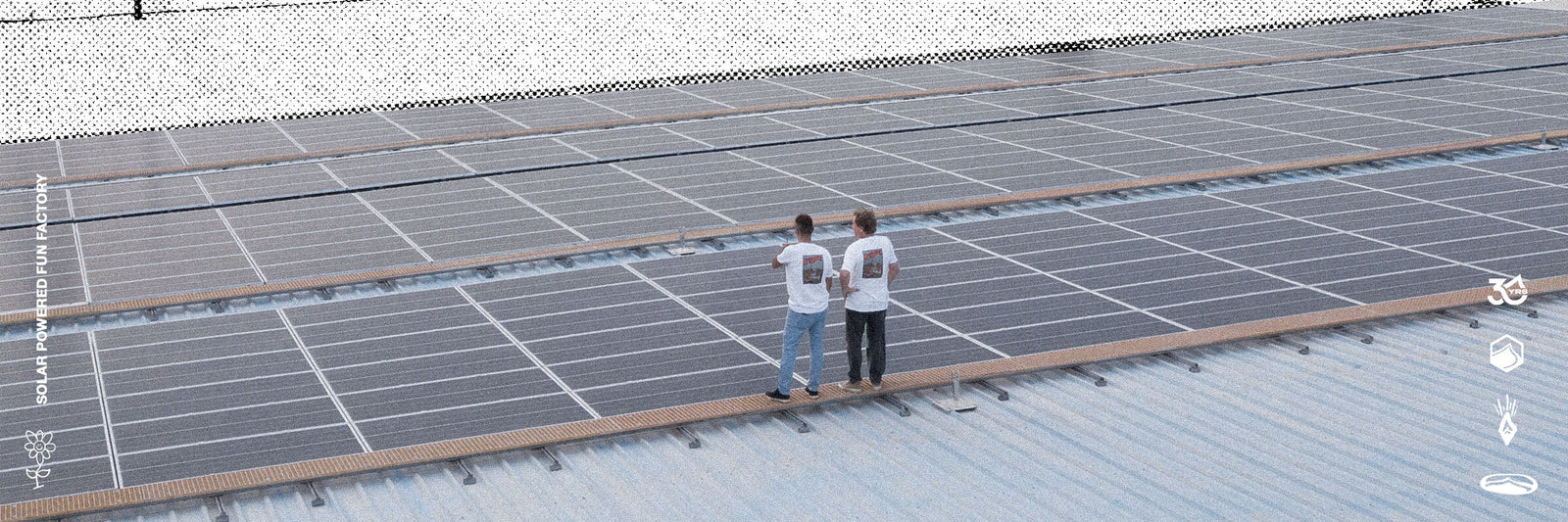 Wide view of two people inspecting solar panels on a rooftop with 'Solar Powered Fun Factory' branding.