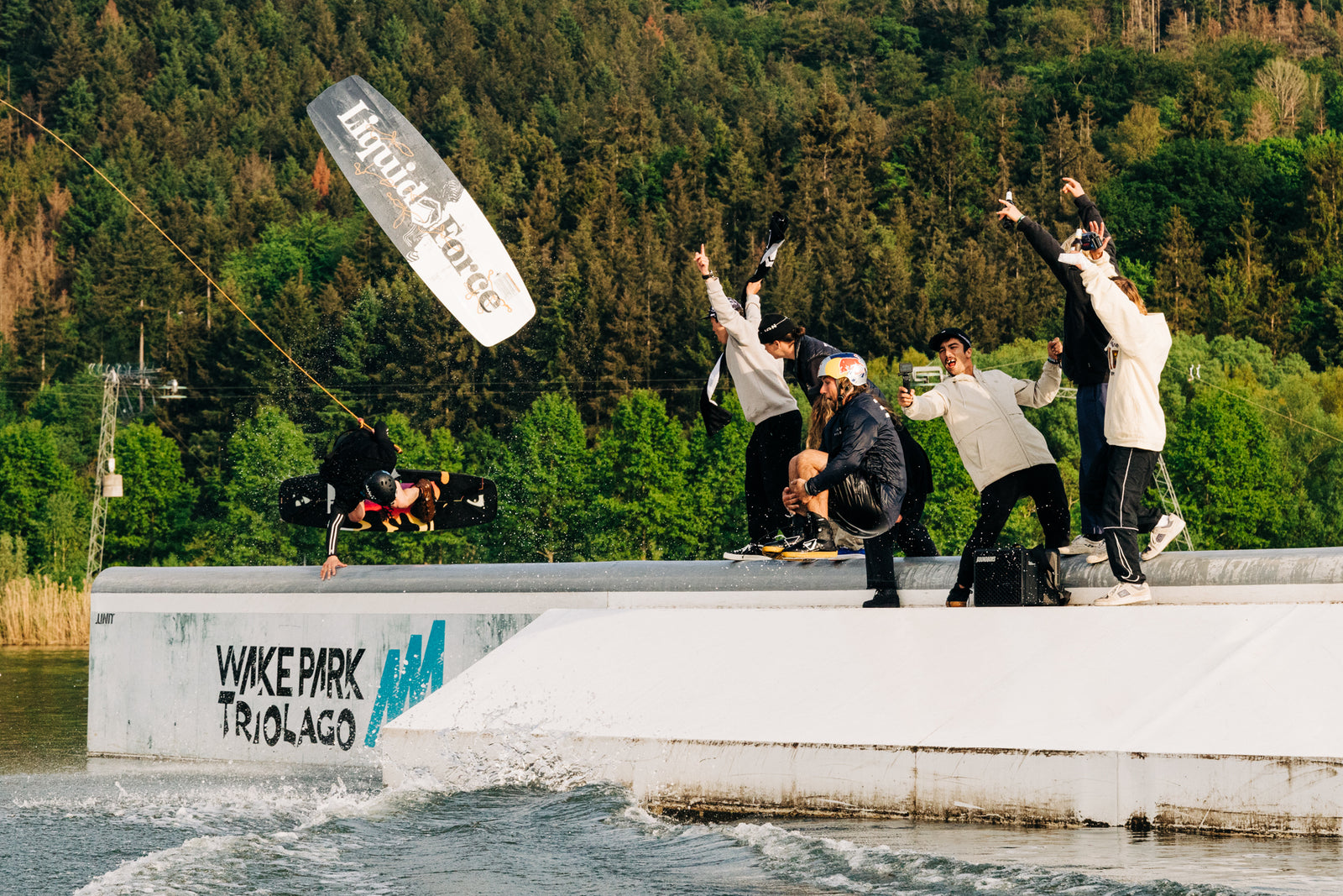 A wakeboarder performs an aerial trick off a ramp at Wakepark Triolago.