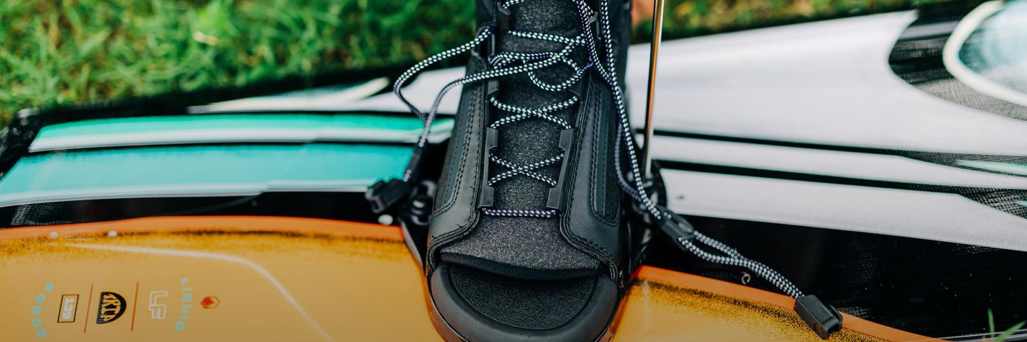 Liquid Force 6R Wakeboard Binding Collection - Closeup shot of someone mounting a LF 6R Chassis Wakeboard Binding on a wakeboard.