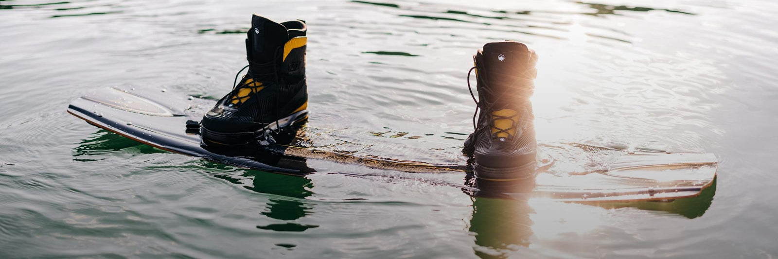 Liquid Force Wakeboard Bindings Collection - Close up picture of LF Wakeboard setup floating in the water