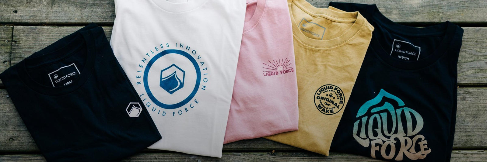 Liquid Force Apparel Collection - Close up picture of various LF T-Shrits folded up next to one another displaying their graphics