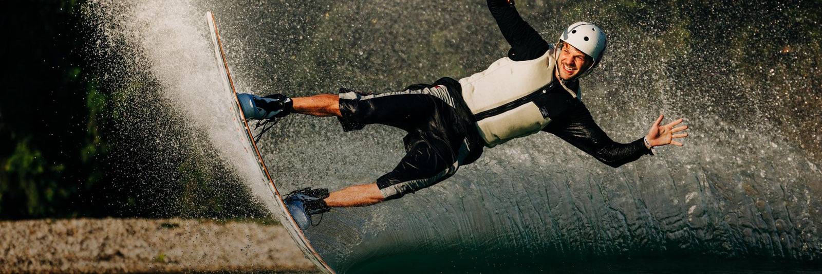 Liquid Force Comp Vest Collection - Closeup shot of LF Athlete Matty Muncey wearing a LF Wakeboard Comp vest carving around a corner on his wakeboard at a cable park
