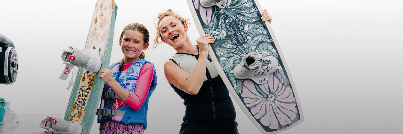 Liquid Force Future Series Collection - Closeup shot of LF Athlete Meagan Ethell and Younger Rider holding their wakeboards.