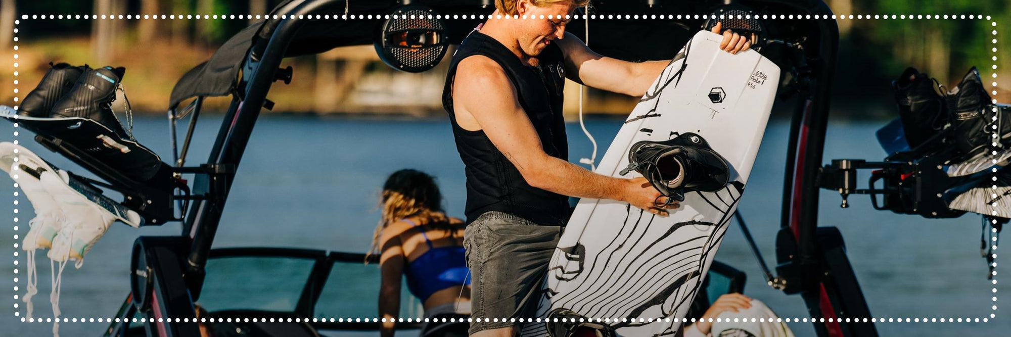 Liquid Force Clearance Wakeboard Package Collection - LF Athlete Luca Kidd holding his wakeboard setup on the back of a boat.