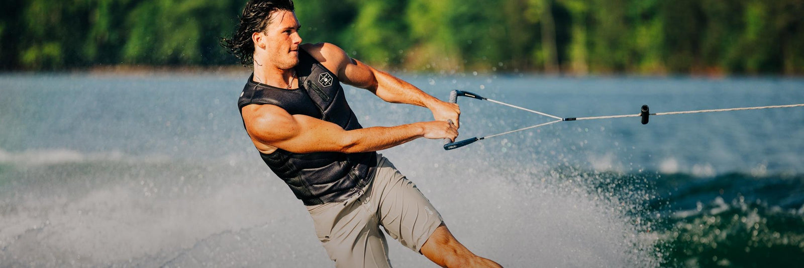 Liquid Force Vest Collection - Closeup shot of LF Athlete Fynn Bullock carving out into the flats on a wakeboard behind a boat wearing a LF Vest.