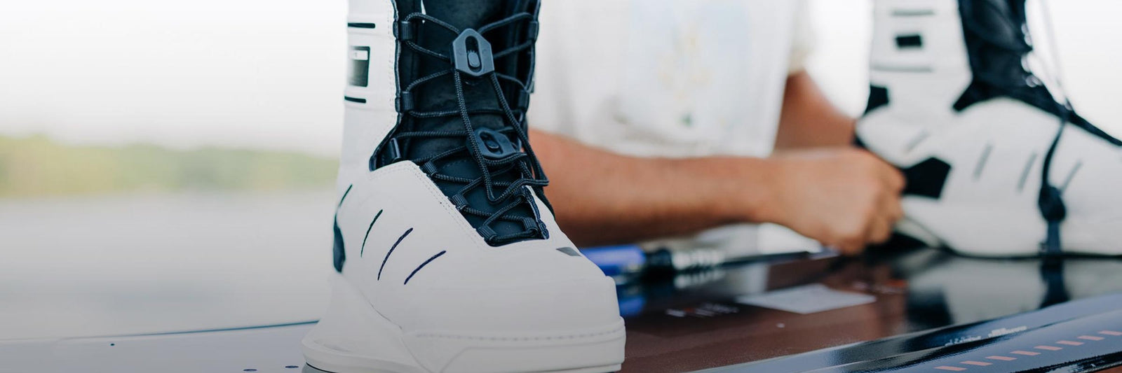 Liquid Force Accessories Collection - Close up picture of LF Athlete Harley Clifford mounting his wakeboard bindings on his wakeboard