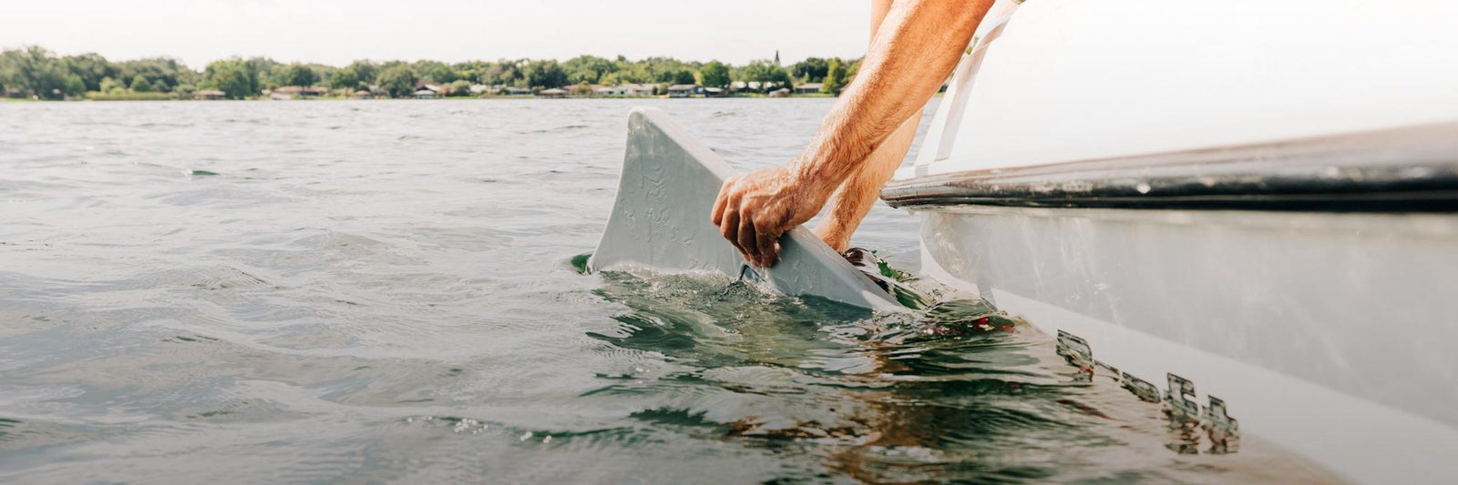 Liquid Force Wake Shaper Collection - Closeup shot of someone mounting a Wakesurf Edge Shaper on the hull of a boat