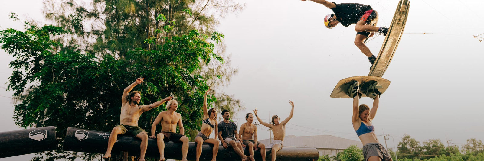 Group cheering as a rider performs a trick on a park wakeboard.