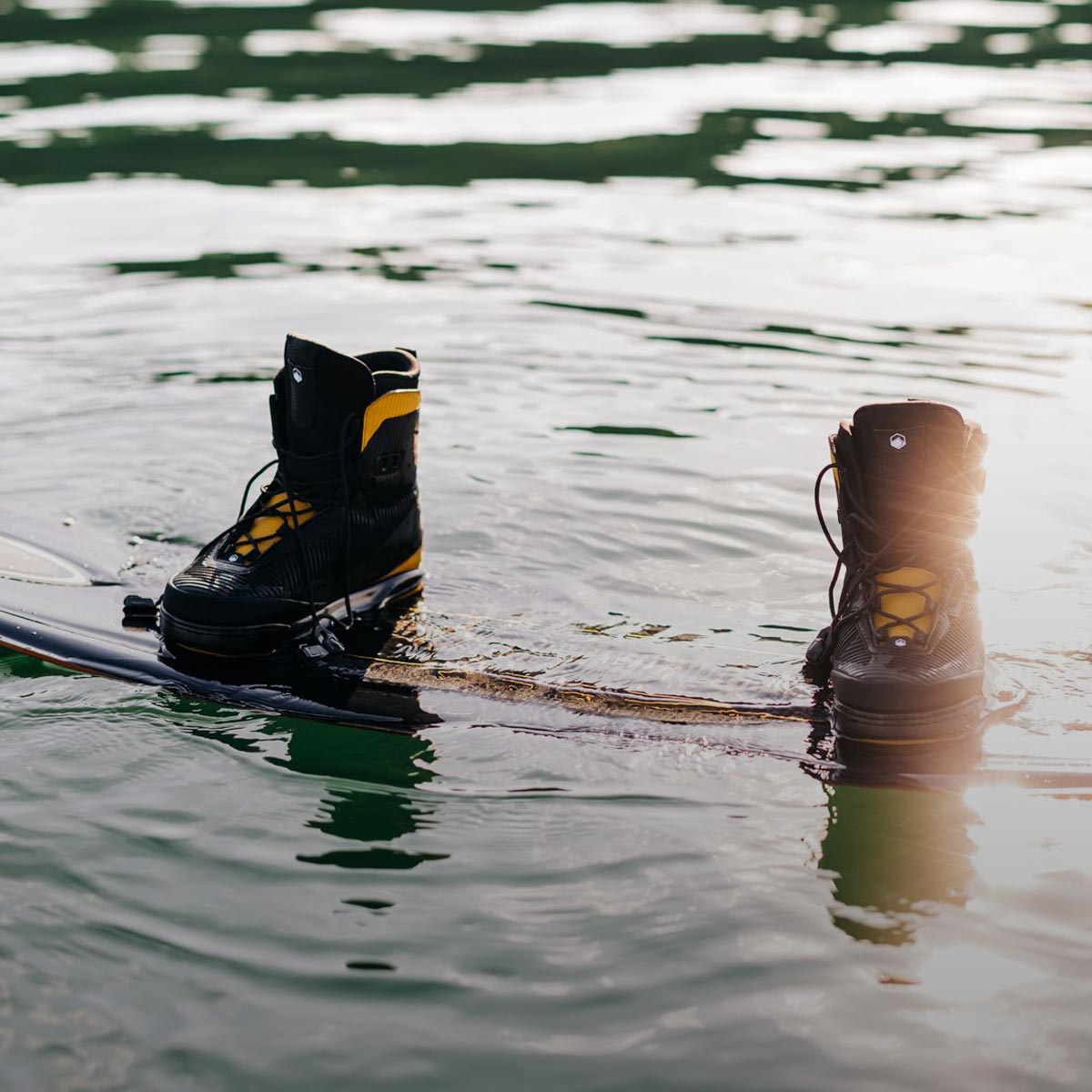 Liquid Force Wakeboard Bindings Collection - Close up picture of LF Wakeboard setup floating in the water
