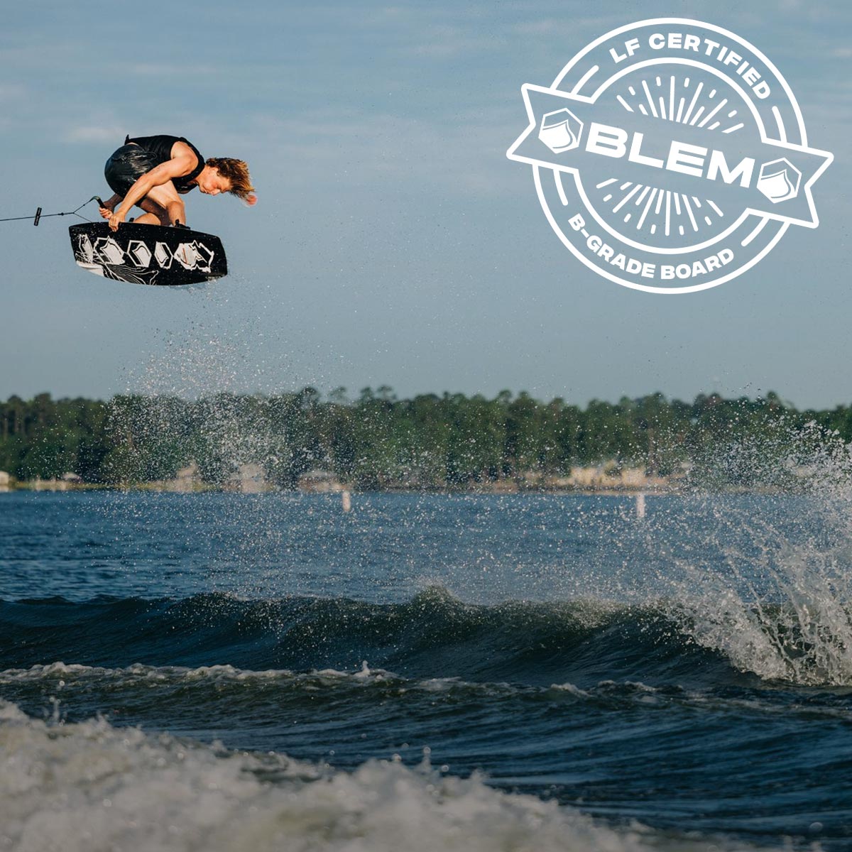 Liquid Force Blem Collection - LF Athlete Luca Kidd grabbing his board mid air behind a wakeboard boat.