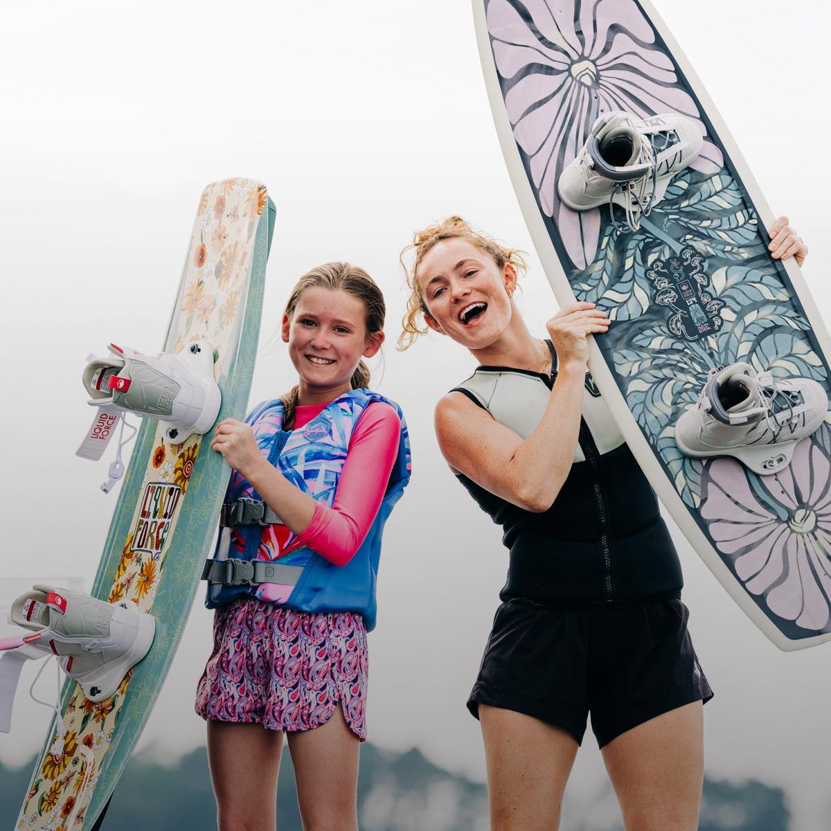 Liquid Force Future Series Collection - Closeup shot of LF Athlete Meagan Ethell and Younger Rider holding their wakeboards.