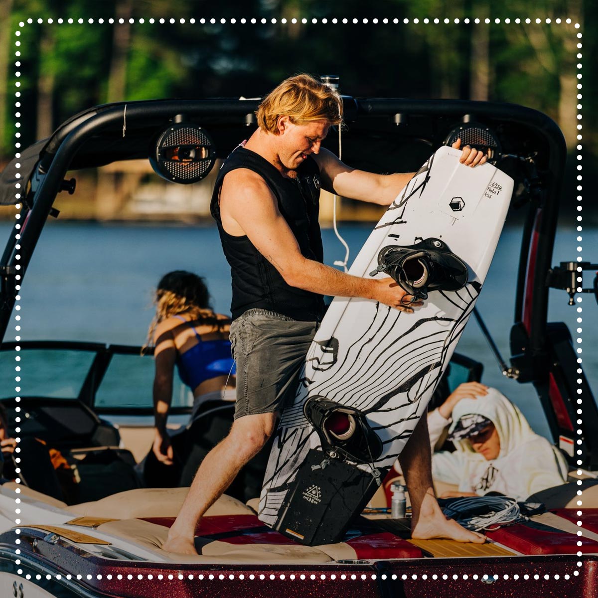 Liquid Force Clearance Wakeboard Package Collection - LF Athlete Luca Kidd holding his wakeboard setup on the back of a boat.
