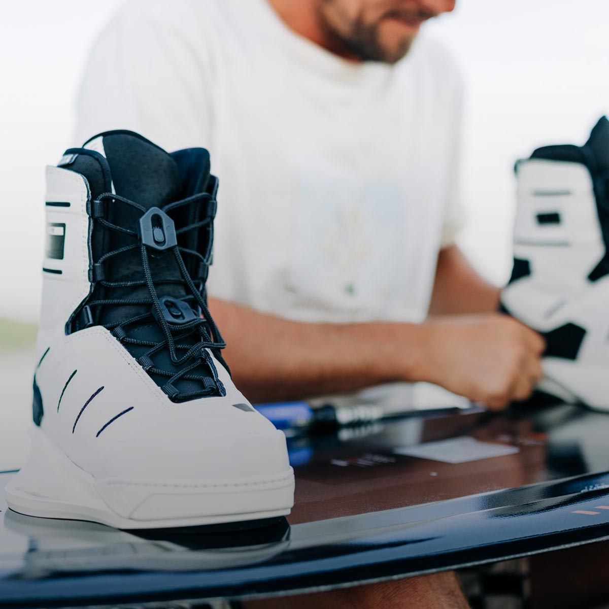 Liquid Force Accessories Collection - Close up picture of LF Athlete Harley Clifford mounting his wakeboard bindings on his wakeboard