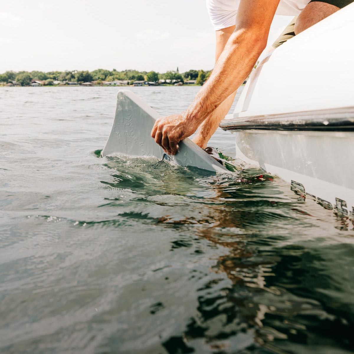 Liquid Force Wake Shaper Collection - Closeup shot of someone mounting a Wakesurf Edge Shaper on the hull of a boat