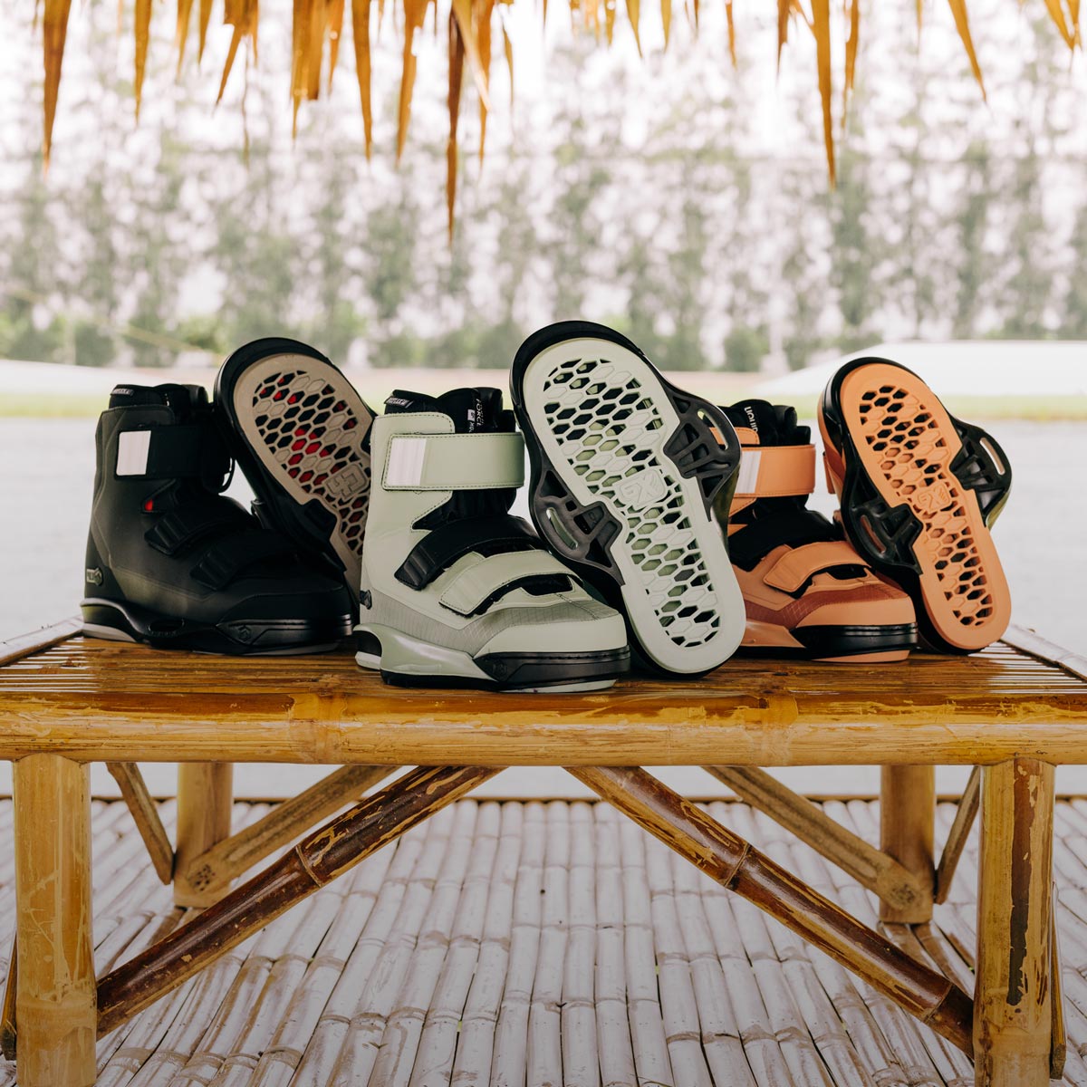 Black, mint, and orange wake bindings displayed on a bamboo table outdoors.