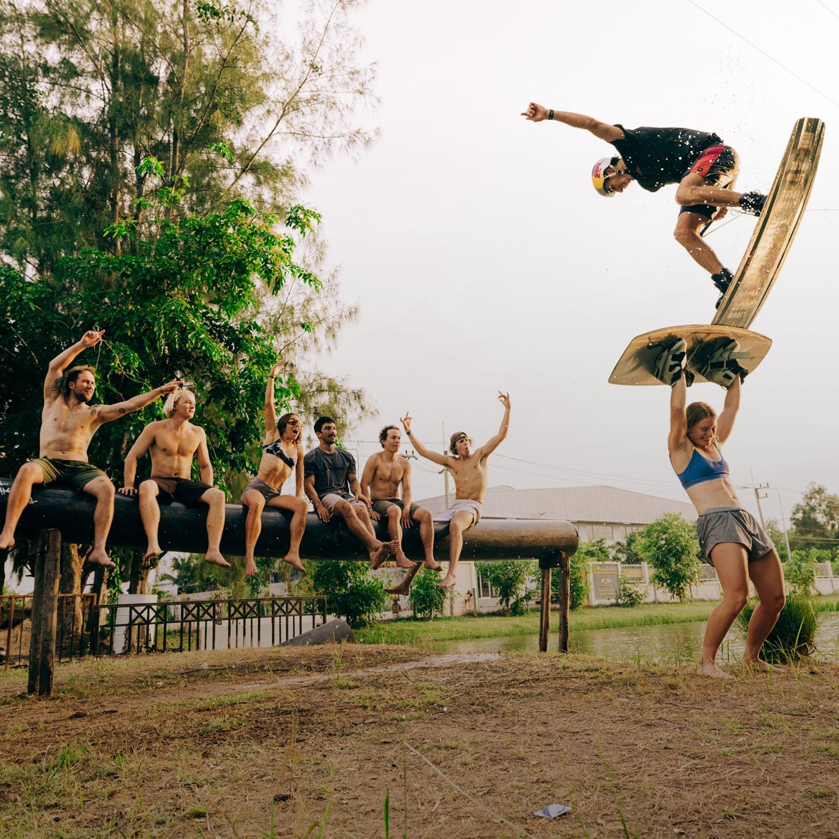 Group cheering as a rider performs a trick on a park wakeboard.