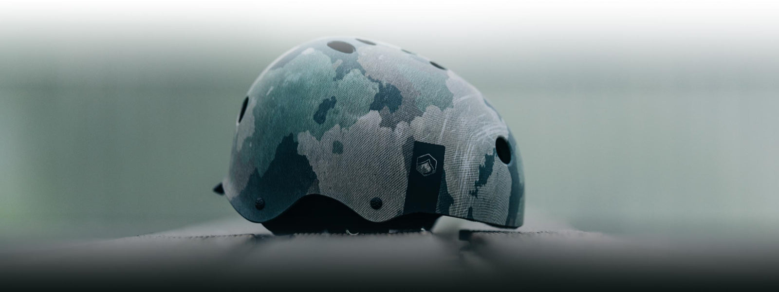 Camouflage-patterned helmet on a reflective surface with a modern flair.