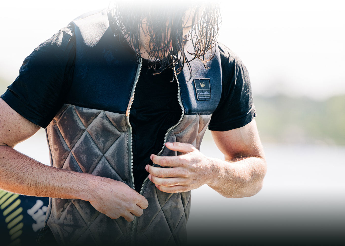 Person unzipping a cozy quilted vest with damp hair.