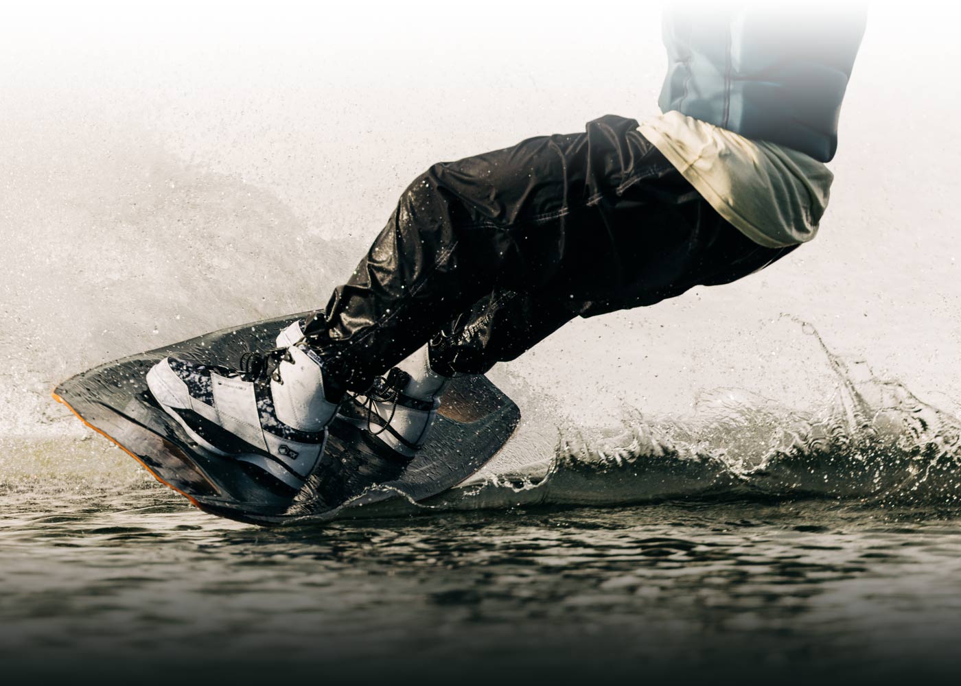 Close-up of a person wakeboarding amid splashing water.