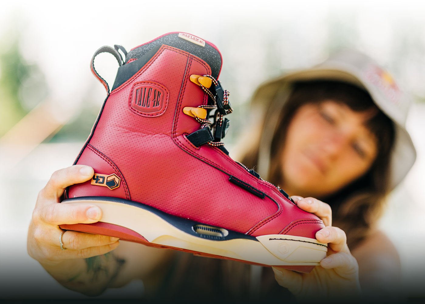 Person displaying a vibrant red wakeboard boot.