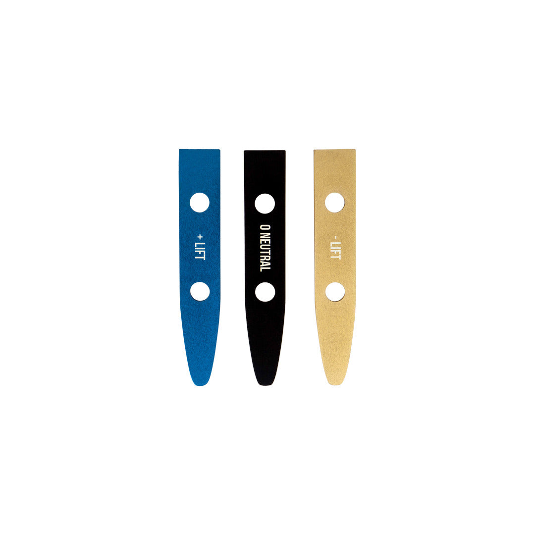 Three thin, rectangular shims in blue, black, and gold with traction labels by Foil Shim Kit.
