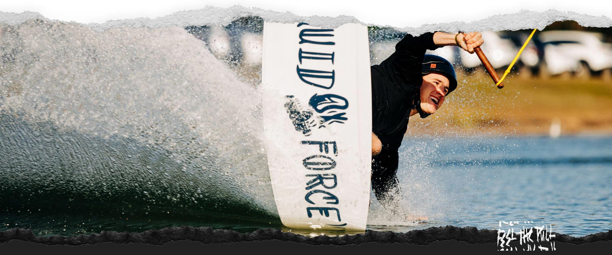 Wakeboarder carving through the water while holding the rope (Liquid Force brand visible).