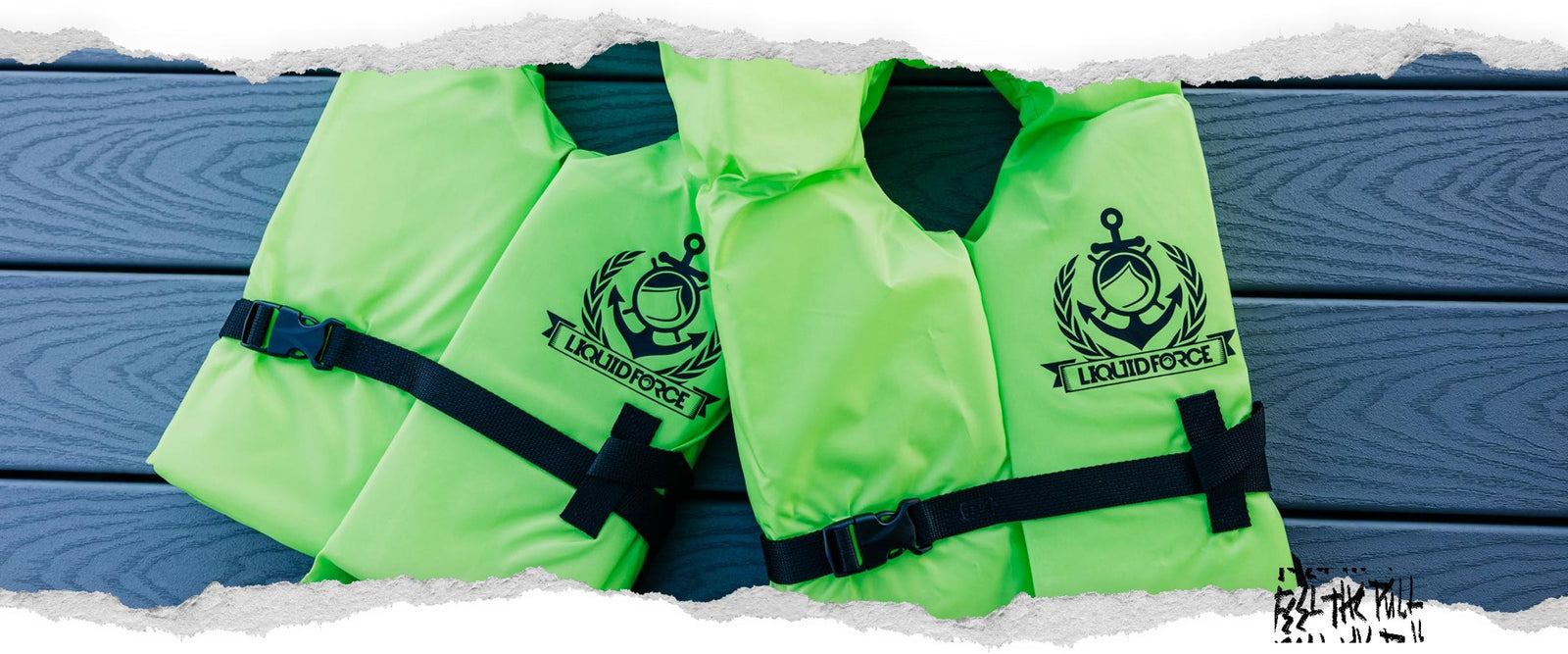 Two neon green Liquid Force CGA vests with anchor logos, side by side on a gray wood dock.