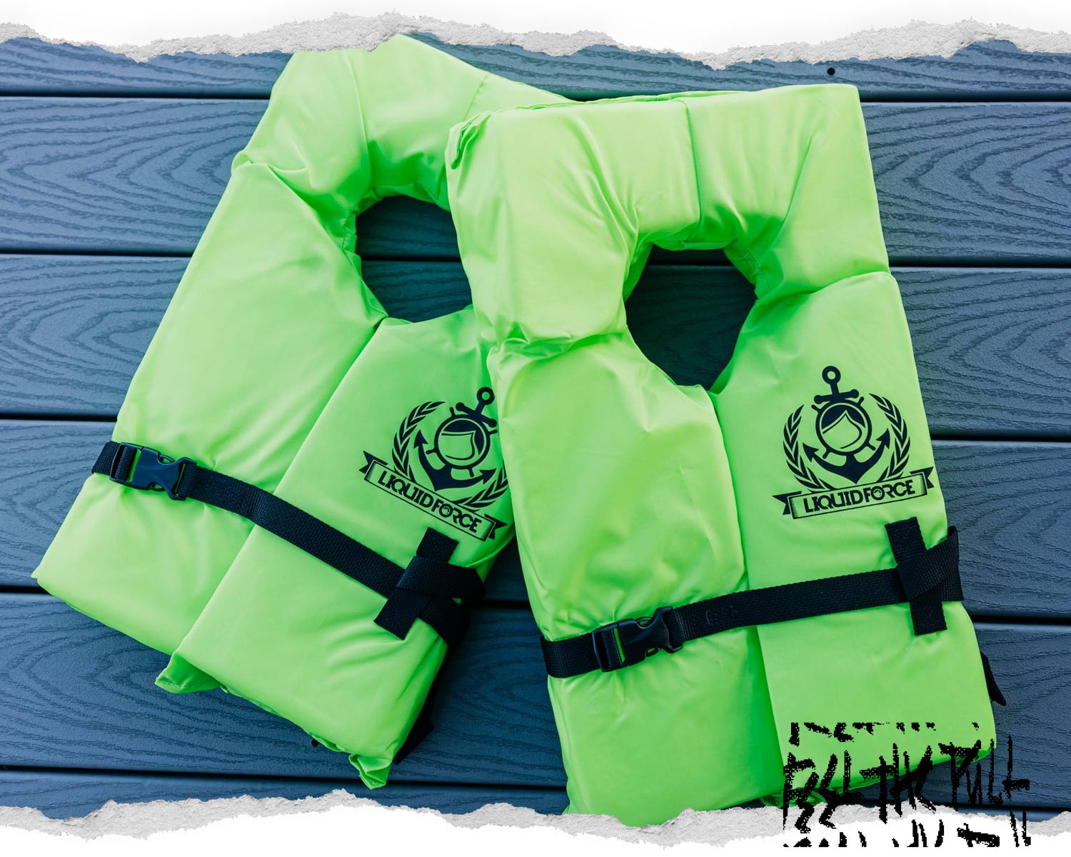 Two neon green Liquid Force CGA vests with anchor logos, side by side on a gray wood dock.