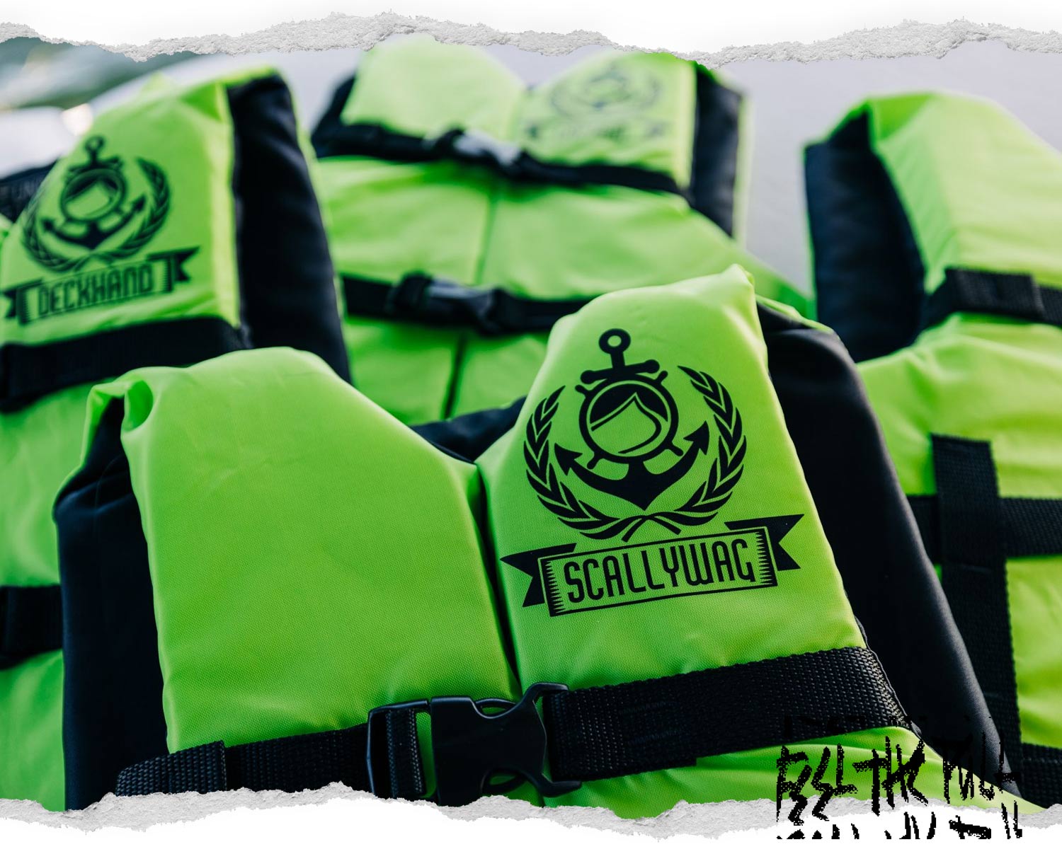 Close-up of neon green CGA vest with Scallywag label and anchor logo, surrounded by similar vests.