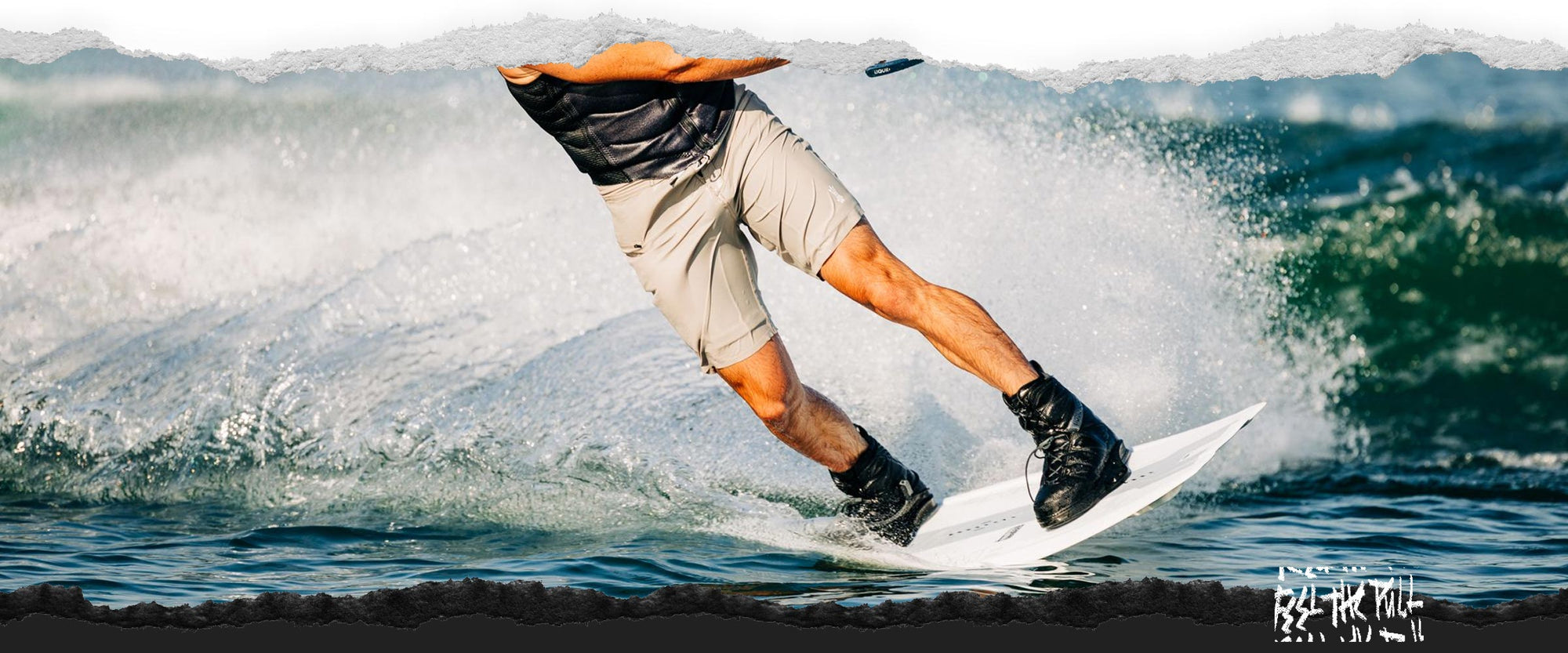 Action shot of rider carving hard in a black vest on a white board.