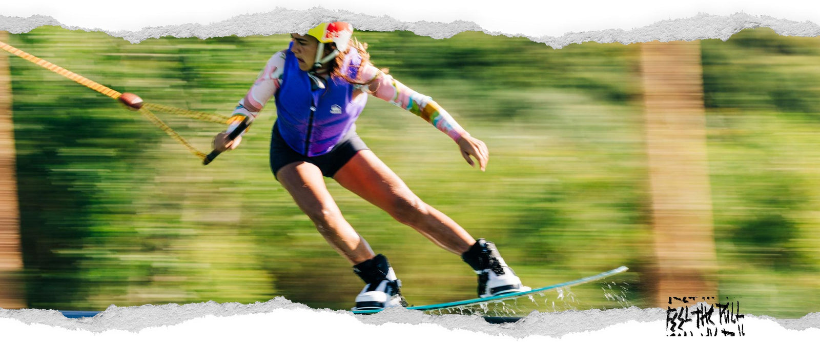 Rider in purple vest grinds across water surface while wakeboarding at high speed.