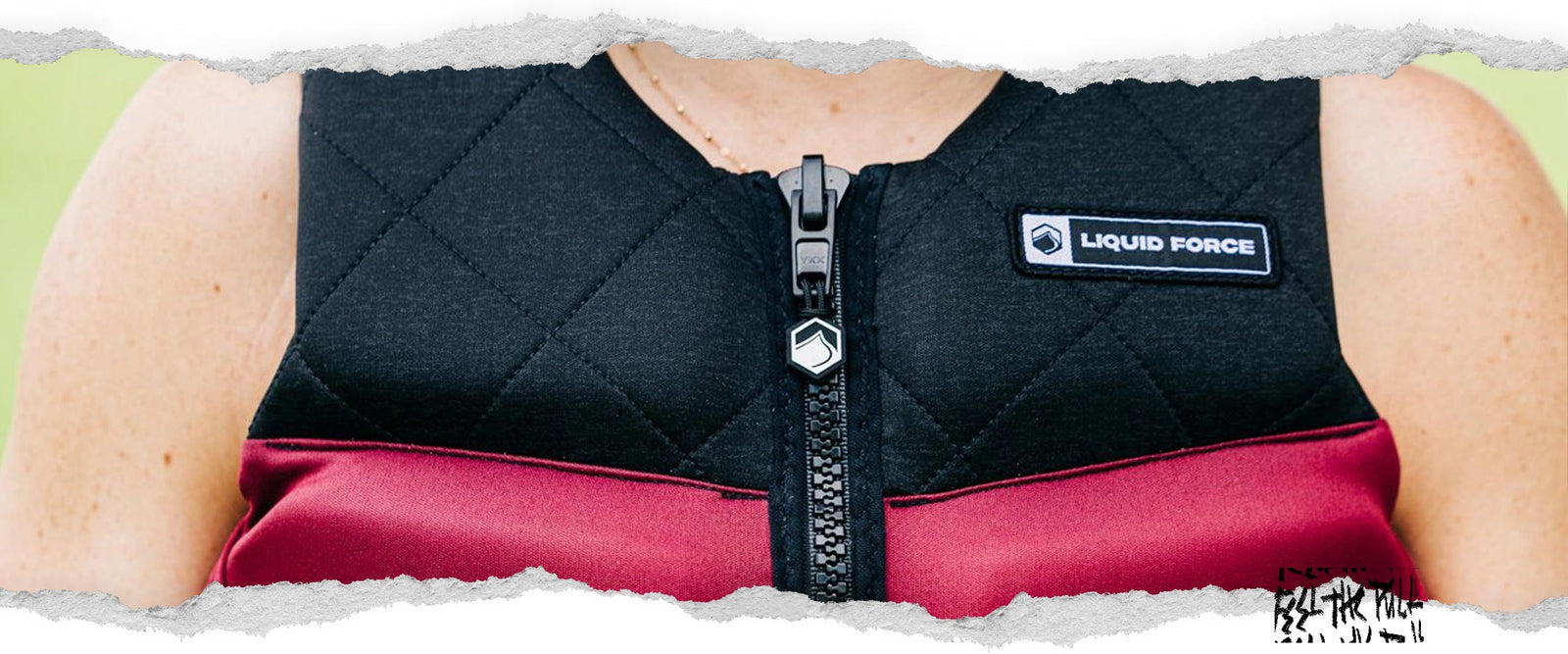 Close-up of maroon and black Diva Heritage CGA vest with quilted shoulders and buckle strap.