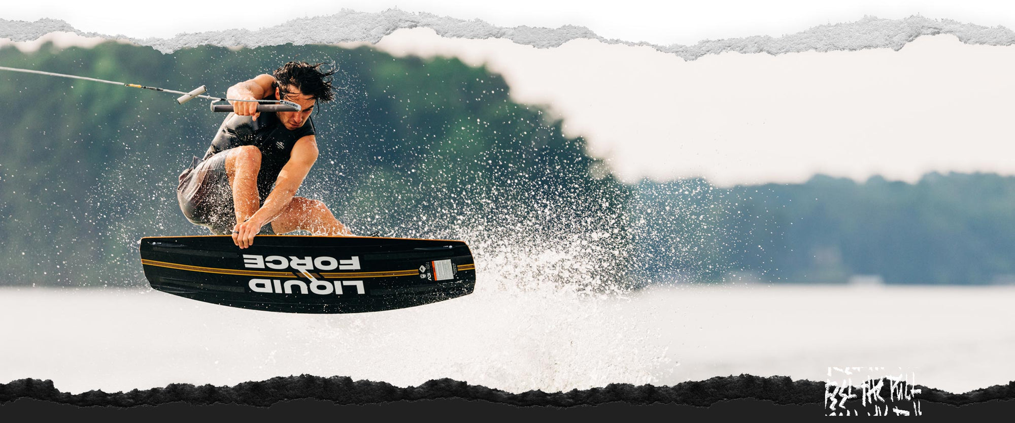 Rider launches off wake on black and yellow Liquid Force board.