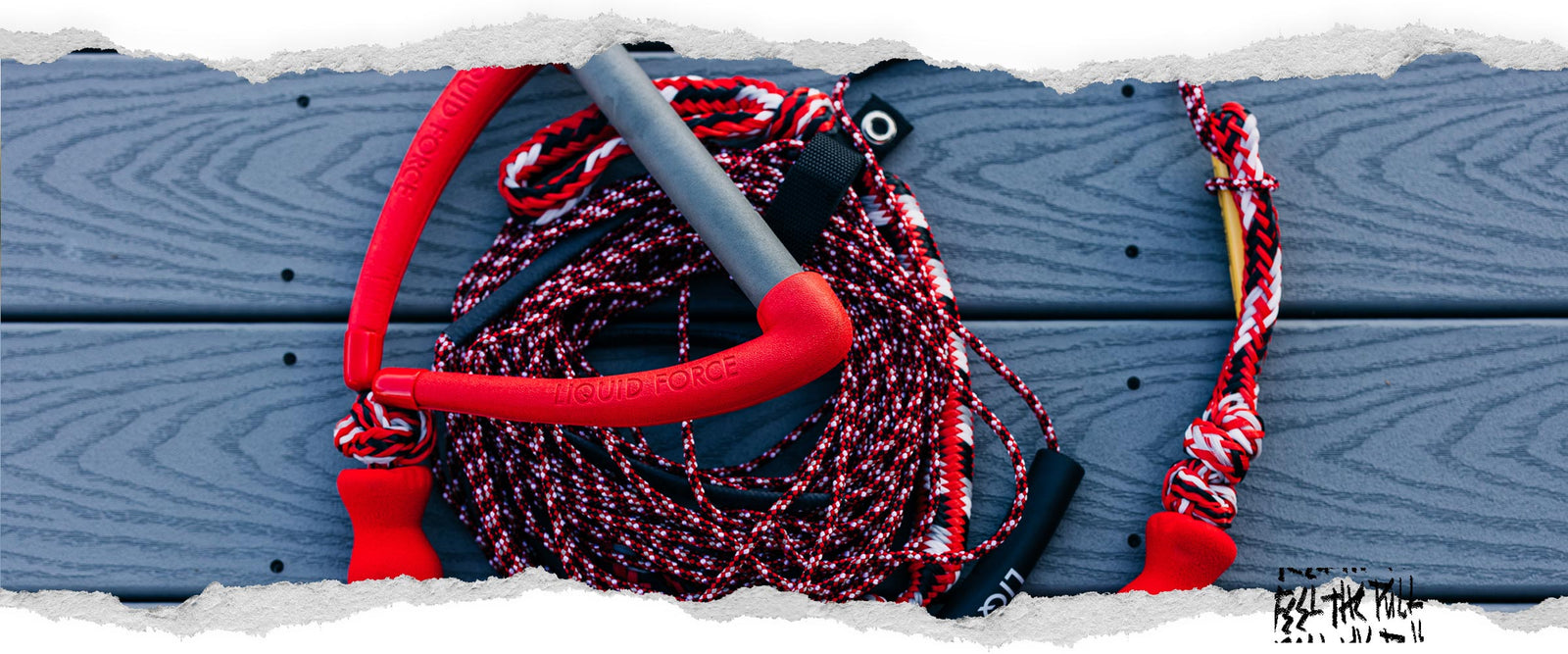 Red Liquid Force wake handle and rope combo with patterned cord on blue decking.