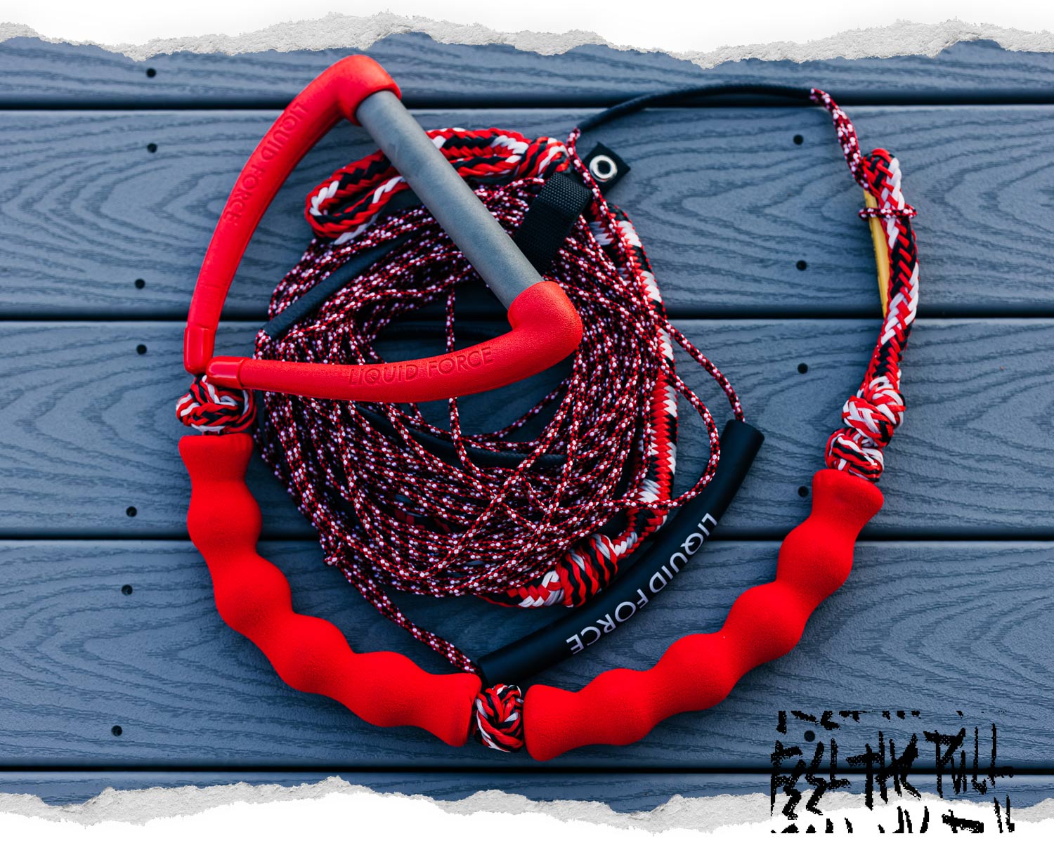 Red Liquid Force wake handle and rope combo with patterned cord on blue decking.