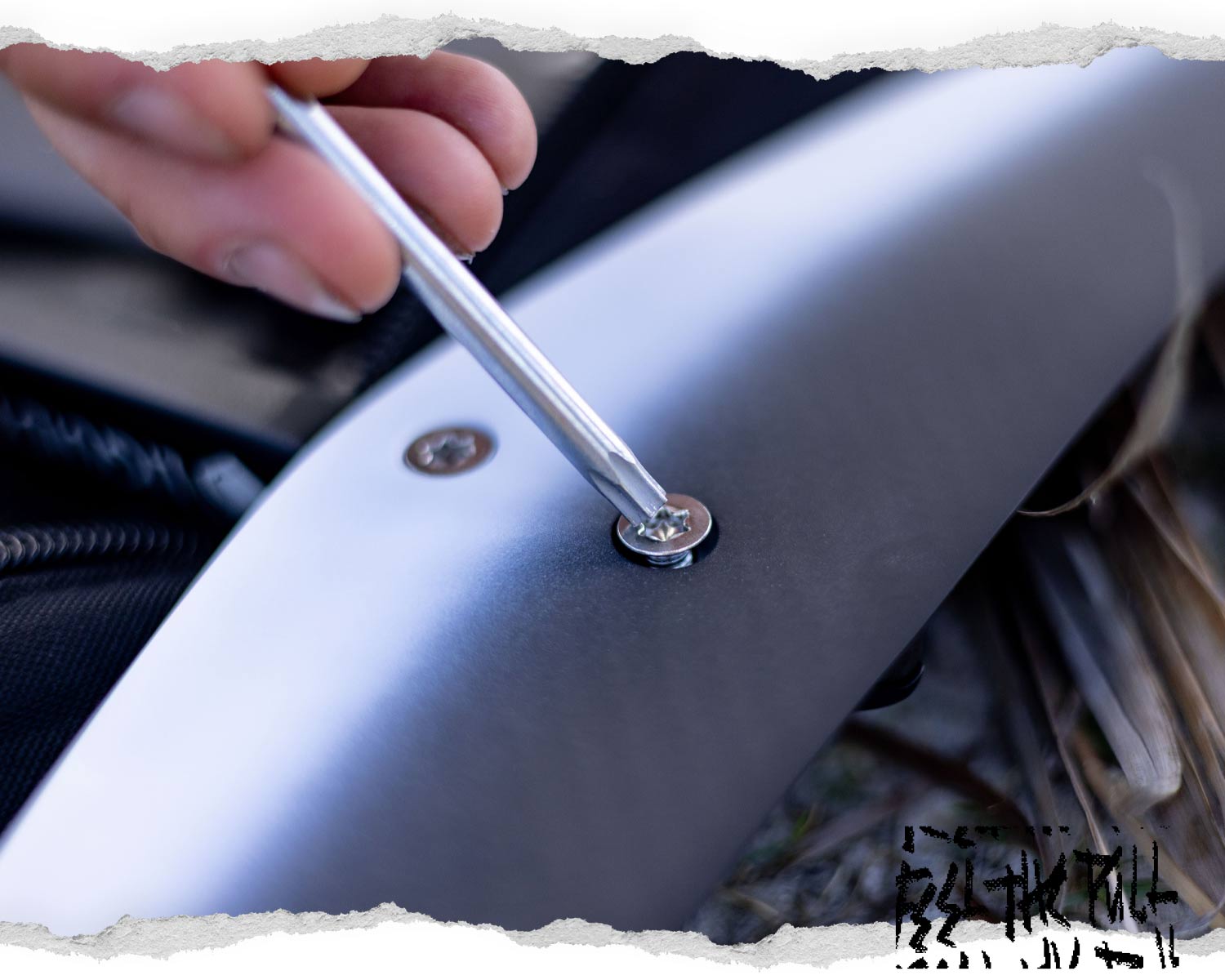 Close-up of screwdriver tightening a foil wing screw on a Liquid Force hydrofoil.