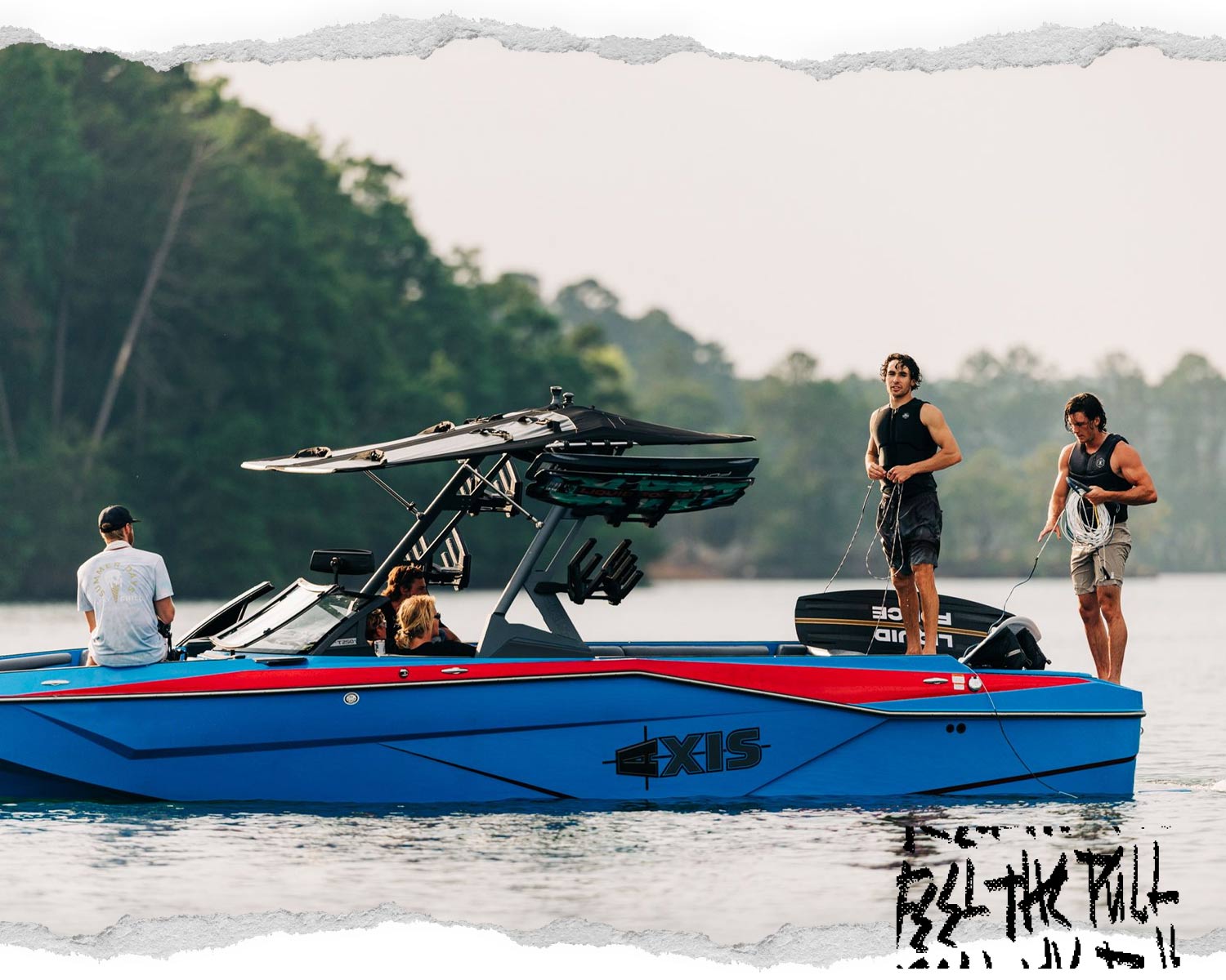 Five people on and around a blue and red Axis boat, two standing with ropes on the rear deck.
