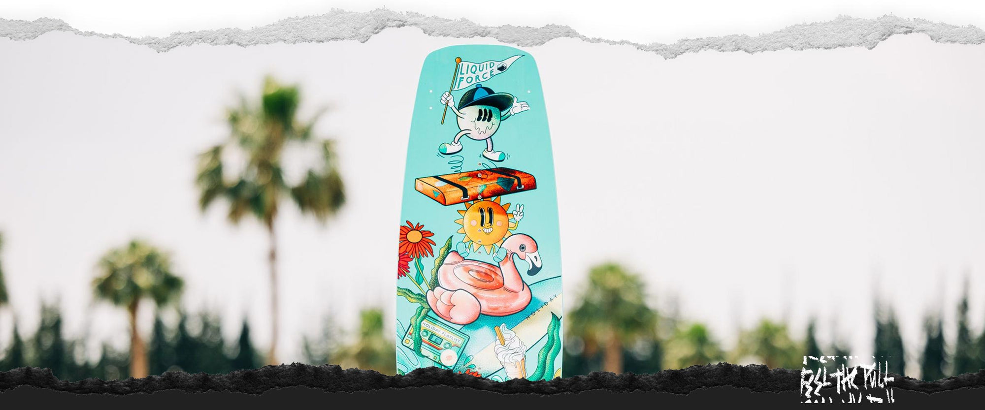 Picture of a the Liquid Force Holiday Future Series Wakeboard standing upright next to water's edge.