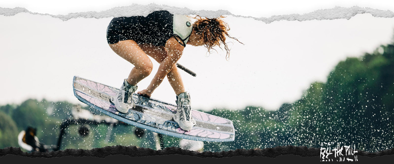 Rider catches air on floral Liquid Force board with white bindings.