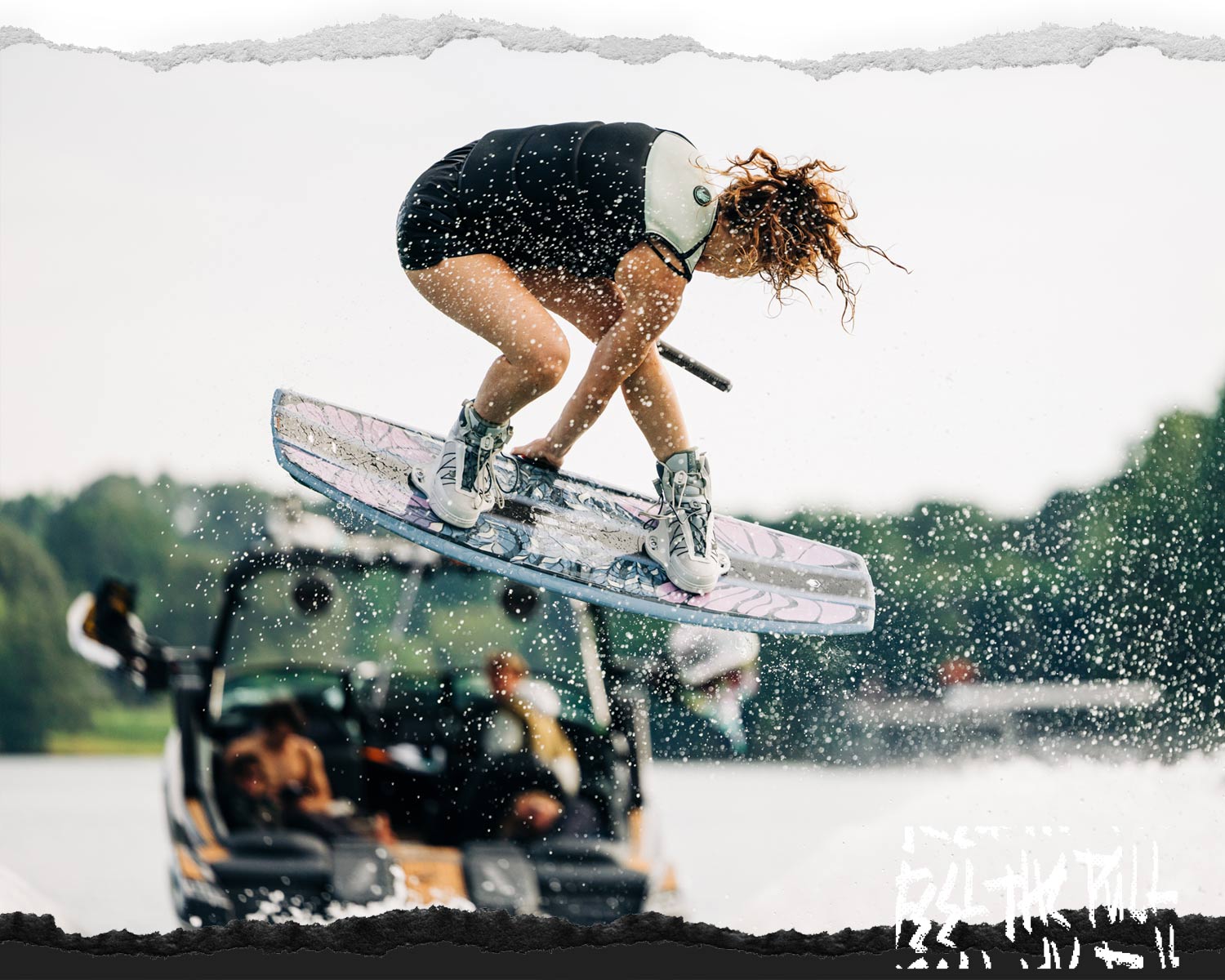 Rider catches air on floral Liquid Force board with white bindings.
