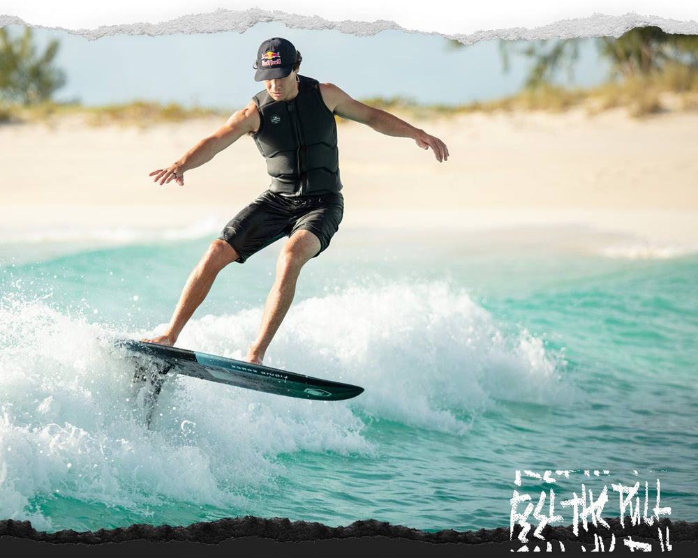 A person surfs on a foil board, balancing skillfully over turquoise waves.