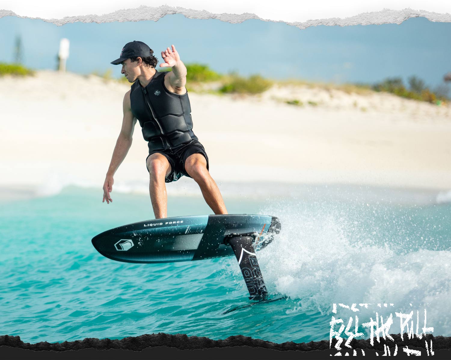 Rider foiling across turquoise ocean water in a black Liquid Force vest.
