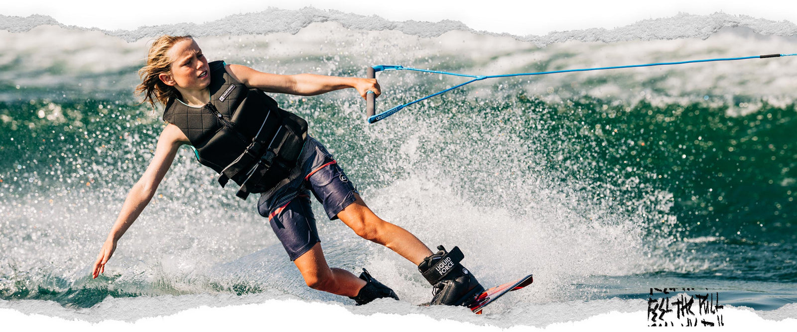 Young rider carving on wakeboard while gripping blue Liquid Force handle.