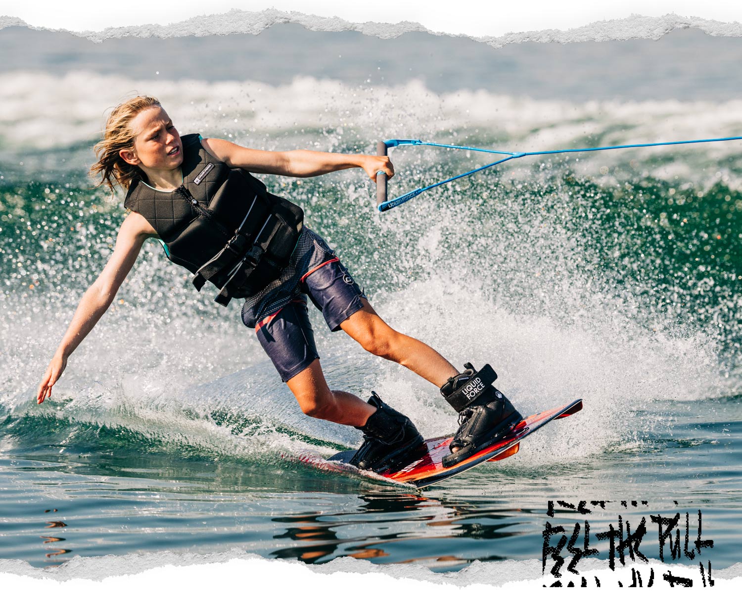 Young rider carving on wakeboard while gripping blue Liquid Force handle.