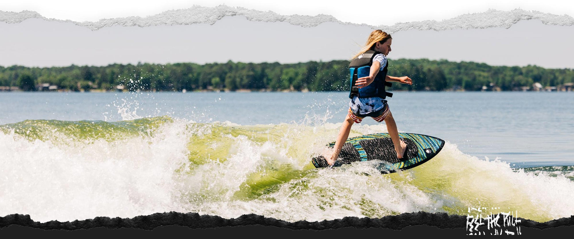 Young person riding the Liquid Force Primo FS Wakesurfer in a blue vest.