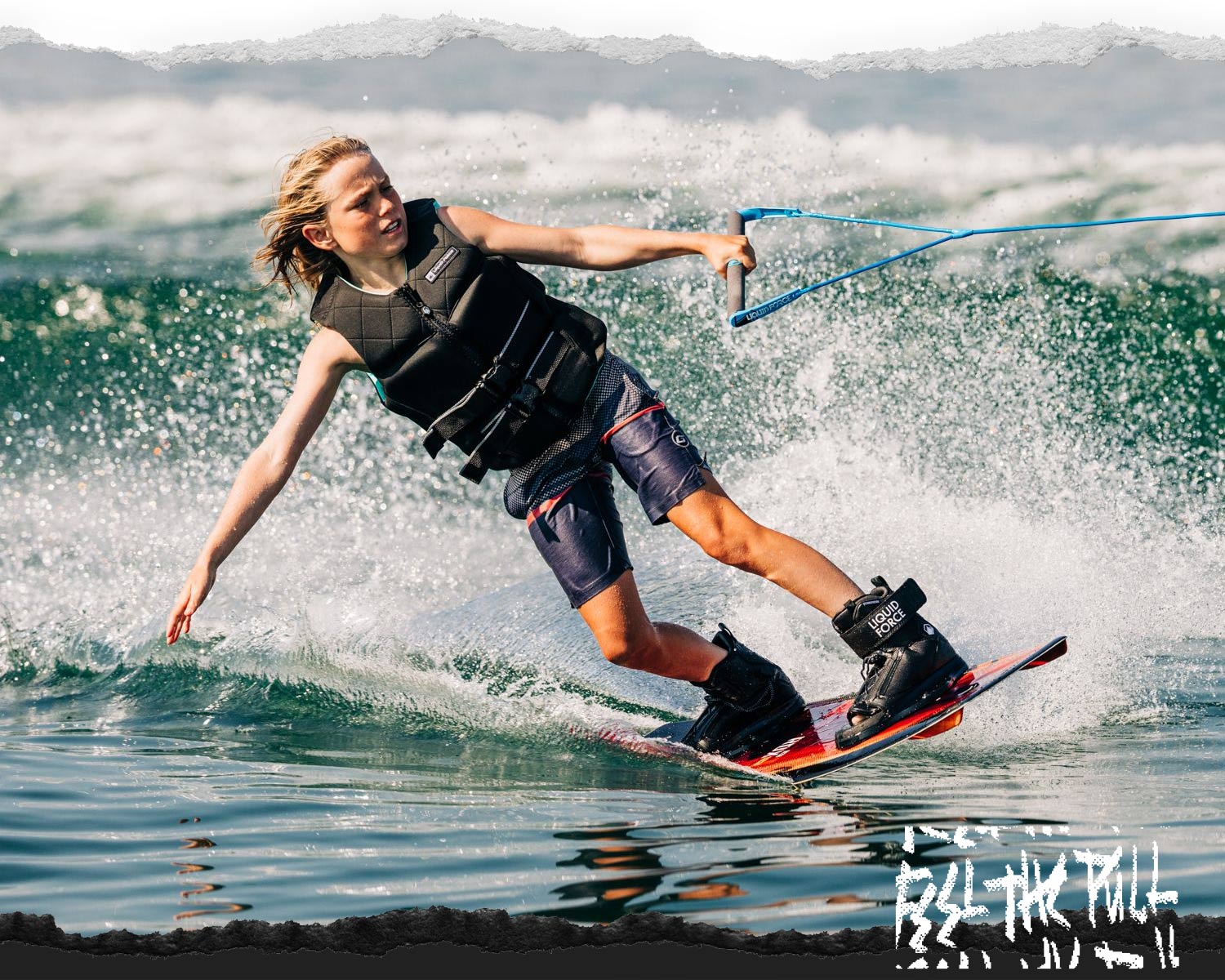 Youth wakeboarder in black vest riding with spray and wearing black Liquid Force boots.