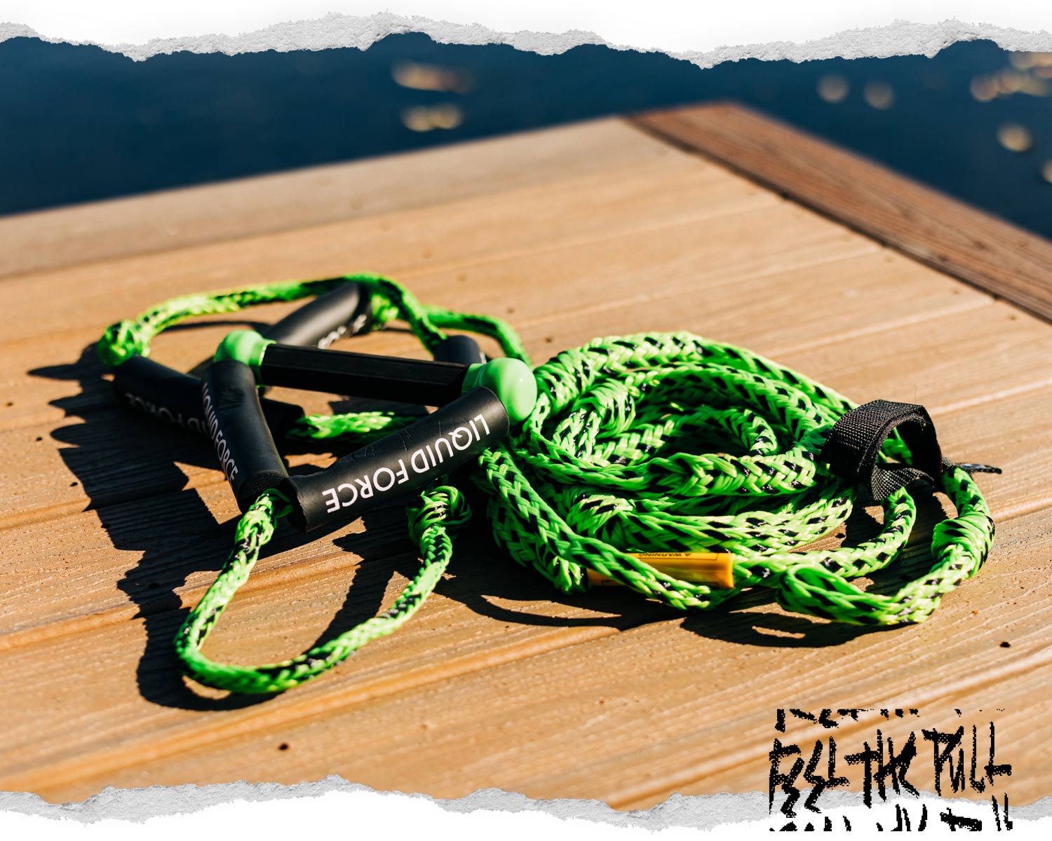 Green Liquid Force handle and rope combo coiled on wood deck.
