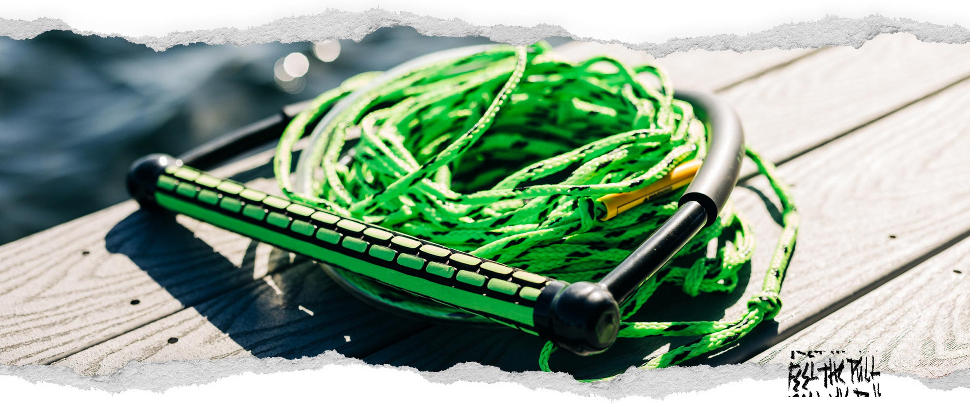 Angled view of Liquid Force TR9 handle with green rope coiled on dock.